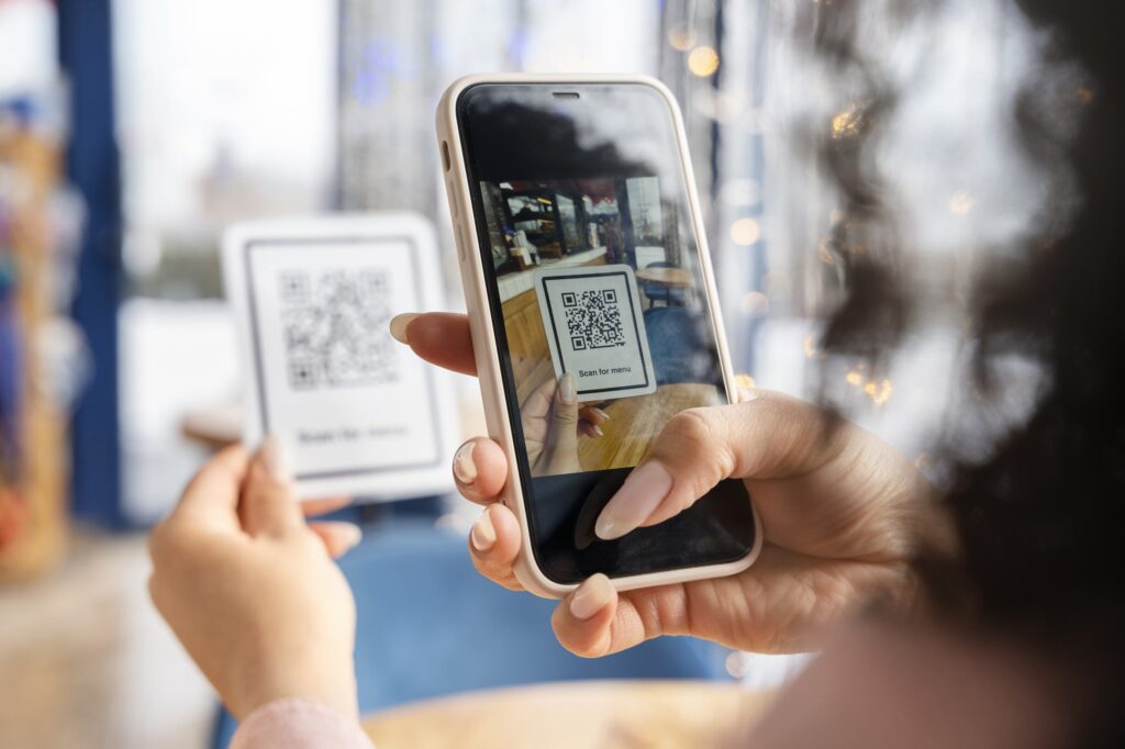 Person scanning a QR code with a smartphone in a bright indoor setting