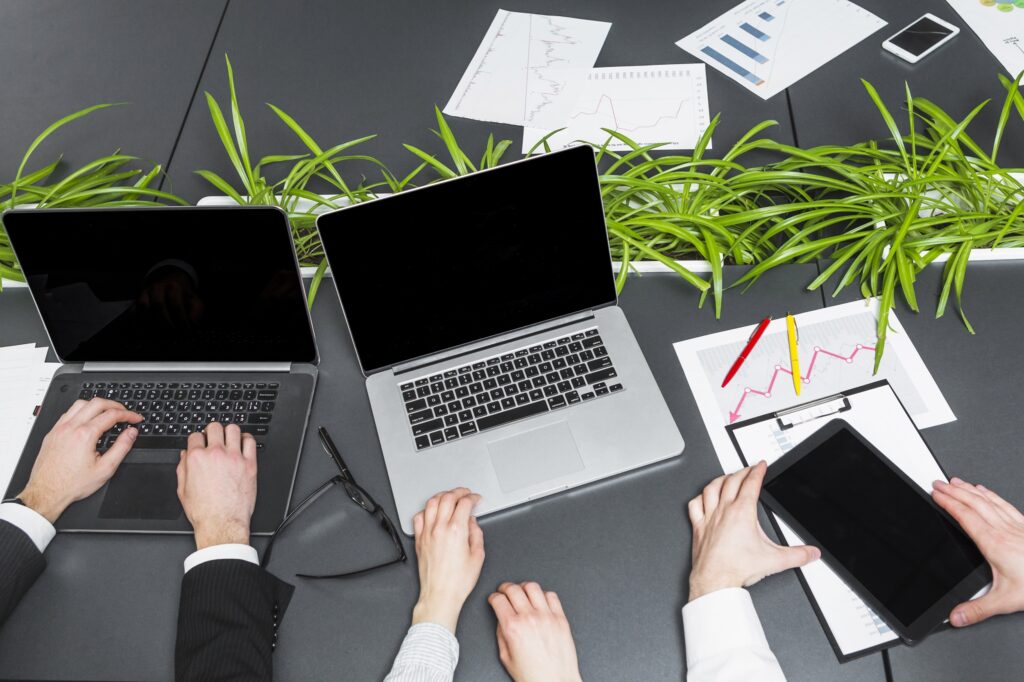 elevated view businesspeople using laptop digital tablet