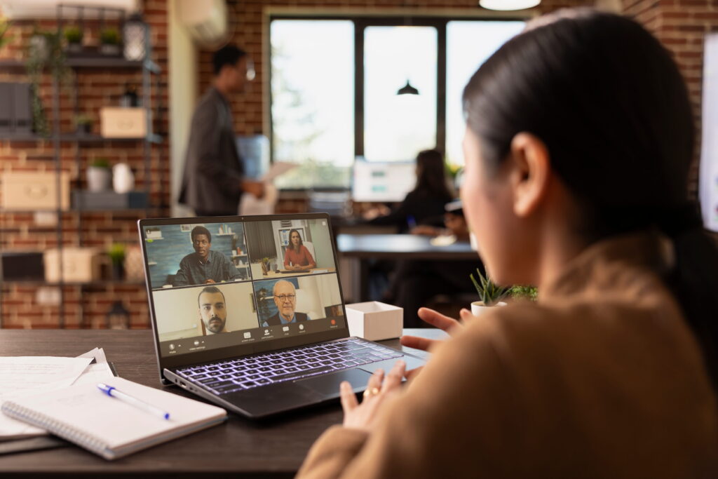 woman attends virtual meeting laptop