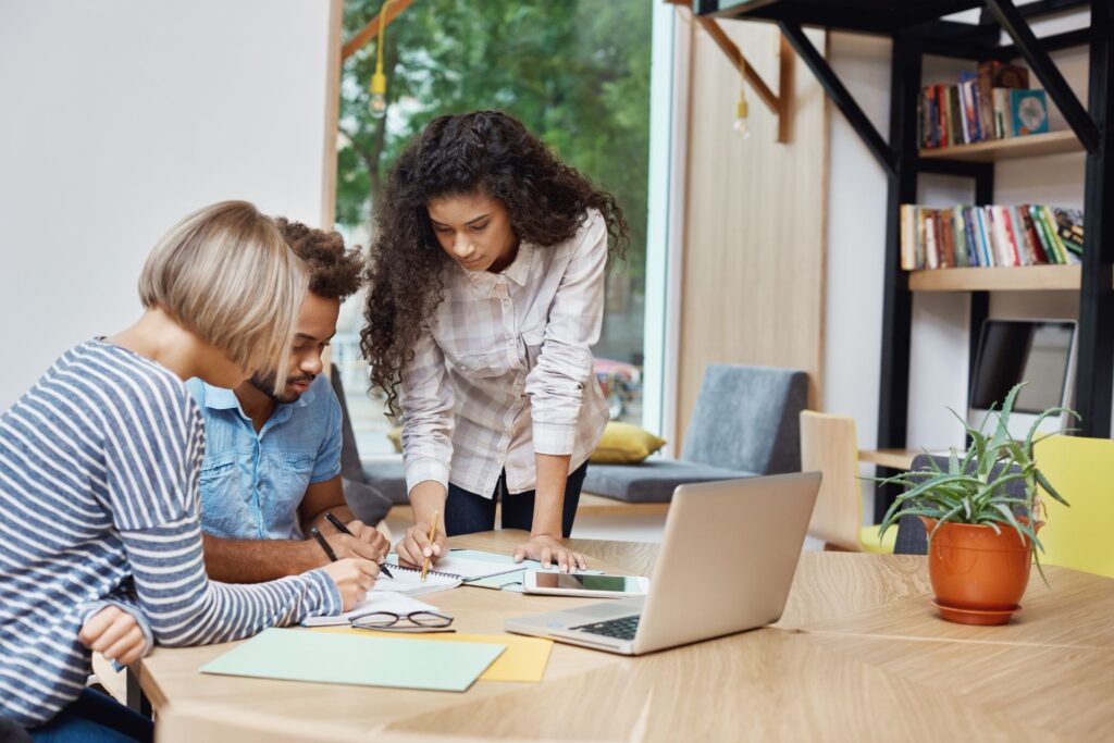 A creative team using a MacBook during a project discussion.